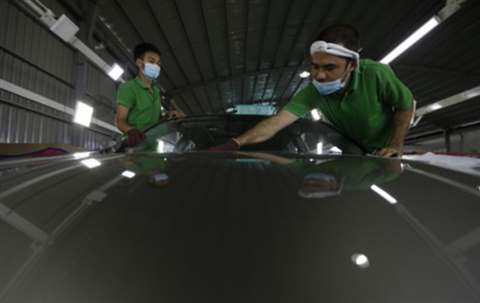 Workers finishing a vehicle body surface