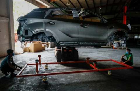 Body shell being positioned on a transport frame