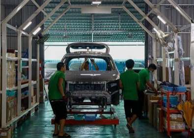 Team assembling a vehicle body on the line