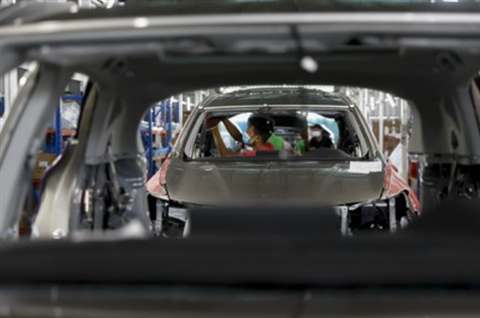 Interior assembly work viewed through a body shell